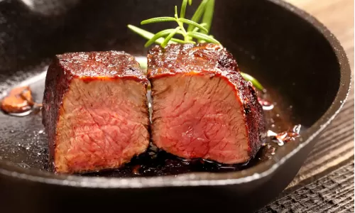 Steak cut in half in cast iron pan