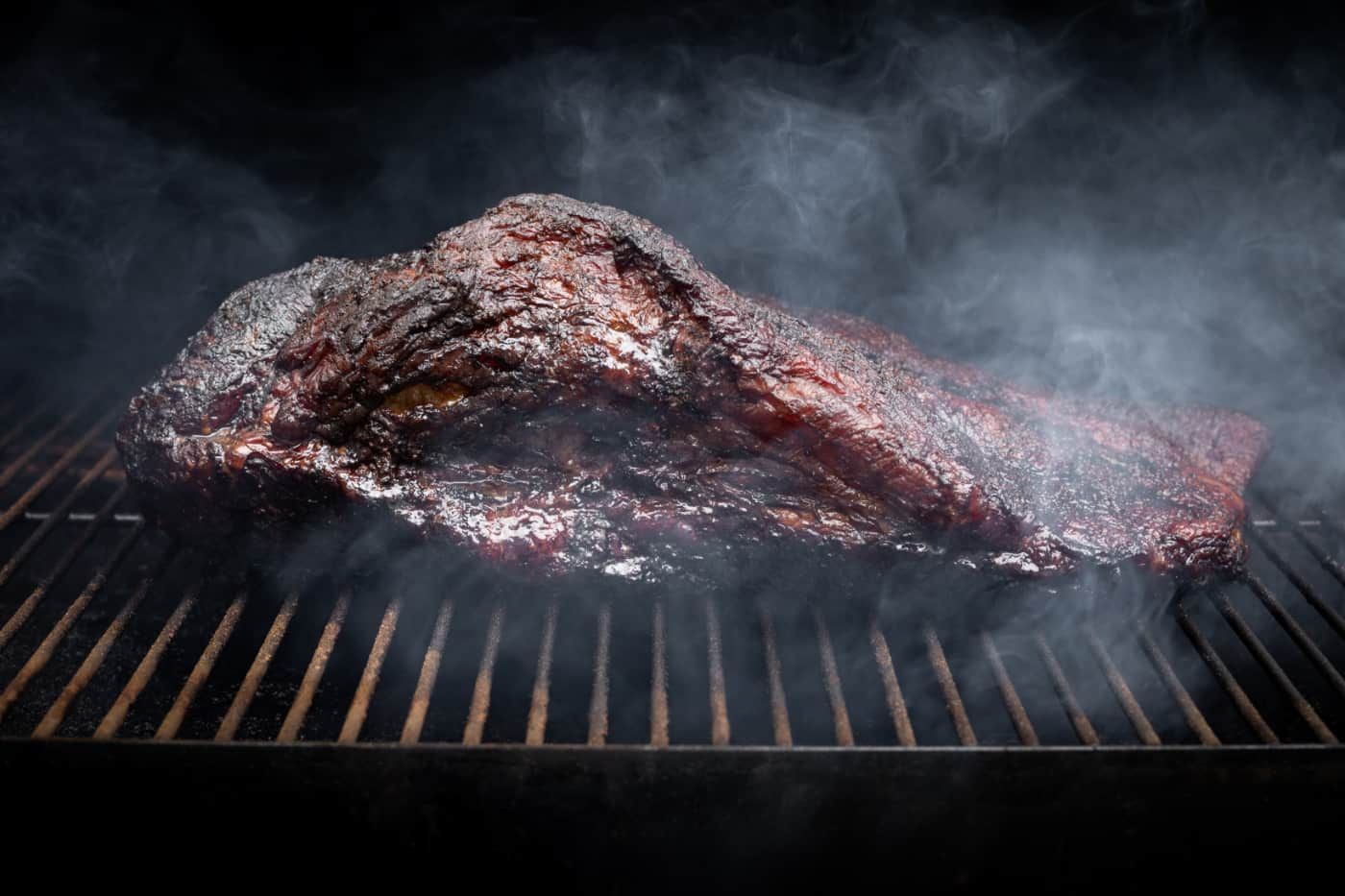 Smoke rising around a slow cooked beef brisket