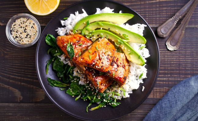 Marinated Salmon and avocado slices top a bed of rice