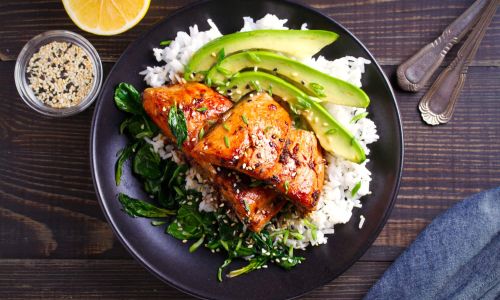 Marinated Salmon and avocado slices top a bed of rice